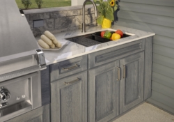 Outdoor kitchen sink, countertop, and gray custom cabinetry in the Jakab project by Mother Hubbard custom cabinetry.