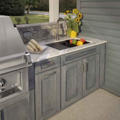 Outdoor kitchen sink, countertop, and gray custom cabinetry in the Jakab project by Mother Hubbard custom cabinetry.