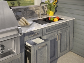 Open pullout storage cabinet beside the outdoor kitchen sink in the Jakab project by Mother Hubbard custom cabinetry.